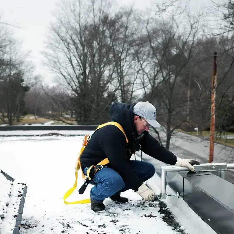 Roth associate crouching and assessing roof