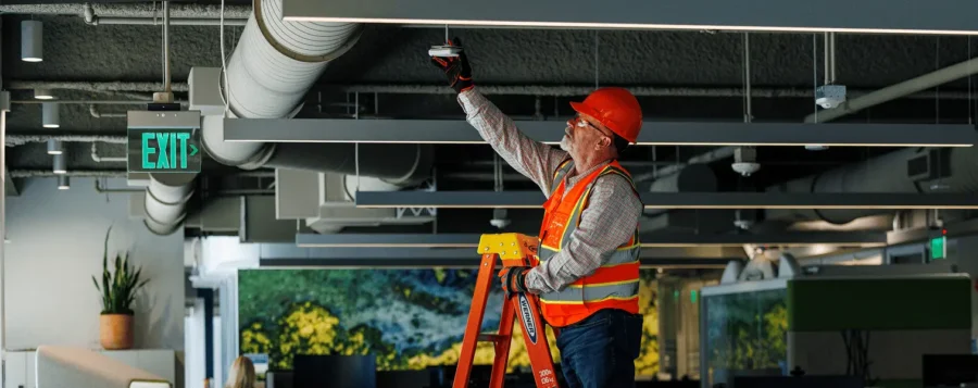 Roth associate on a ladder changing bulb